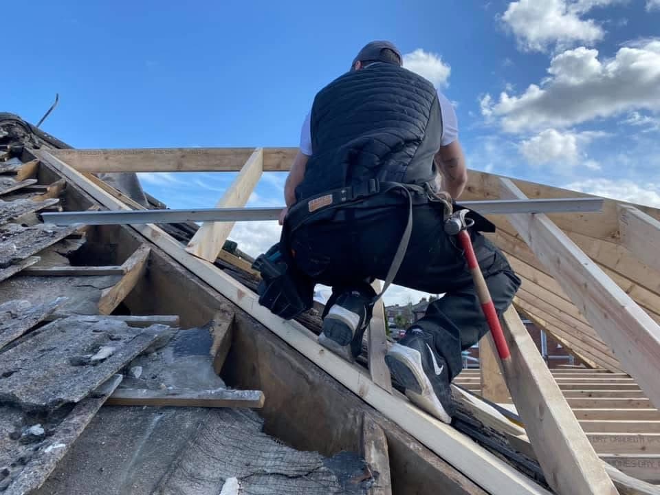 Joiner working on roof timbers during a re-roof
